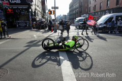 A wheelchair racer "pedals" his way through the course using his hands.