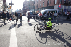 A wheelchair racer acknowledges the support of spectators along the route.