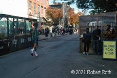 In previous years Brooklyn's Bedford Avenue was cleared from curb to curb but some restaurant "outdoor dining structures" restricted the space available for runners. No one was having a meal as this runner passed.
