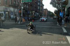A wheelchair racer if backed up by an NYPD Highway patrol car to ensure safety.