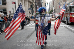 A man carrying and wrapped in American flags participates in the 102nd Veterans Day Parade along 5th Avenue in New York, New York, on Nov. 11, 2021. (Photo by Gabriele Holtermann/Sipa USA)