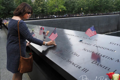 NEW YORK, NEW YORK - SEPTEMBER 11: Flags and flowers adorn the names of the victims of the attacks of Sept. 11, 2001, during a ceremony at the 9/11 Memorial and Museum on September 11, 2021 in New York City. The nation is marking the 20th anniversary of the terror attacks of September 11, 2001, when the terrorist group al-Qaeda flew hijacked airplanes into the World Trade Center, Shanksville, PA and the Pentagon, killing nearly 3,000 people.