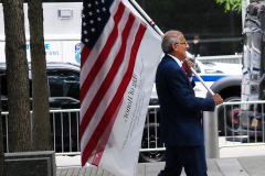 A man carries the American flag at the National 9/11 Memorial and Museum during the ceremony commemorating the 20th anniversary of the 9/11 attacks on the World Trade Center, in New York, on September 11, 2021.