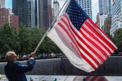 A man waves a "flag of honor" for those lost on 9/11 at the South Pool of the 9/11 memorial. 
Hundreds of people came to the memorial to pay tribute to their family members and loved ones marking the 20th anniversary of the tragedy that struck NYC and shocked the world on 9/11/01. (C) Bianca Otero