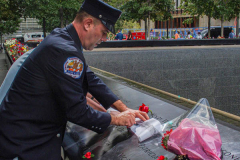 A family place flowers and make a pencil rubbing of the name of their lost family member at the North Pool of the 9/11 memorial. 
Hundreds of people came to the memorial to pay tribute to their family members and loved ones marking the 20th anniversary of the tragedy that struck NYC and shocked the world on 9/11/01. (C) Bianca Otero
