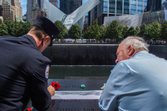 Two men make a pencil rubbing of the name of their lost family member at the North Pool of the 9/11 memorial. 
Hundreds of people came to the memorial to pay tribute to their family members and loved ones marking the 20th anniversary of the tragedy that struck NYC and shocked the world on 9/11/01. (C) Bianca Otero