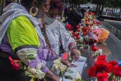 A family place flowers and make a pencil rubbing of the name of their lost family member at the North Pool of the 9/11 memorial. 
Hundreds of people came to the memorial to pay tribute to their family members and loved ones marking the 20th anniversary of the tragedy that struck NYC and shocked the world on 9/11/01. (C) Bianca Otero