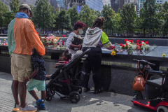 A family place flowers and make a pencil rubbing of the name of their lost family member at the North Pool of the 9/11 memorial. 
Hundreds of people came to the memorial to pay tribute to their family members and loved ones marking the 20th anniversary of the tragedy that struck NYC and shocked the world on 9/11/01. (C) Bianca Otero