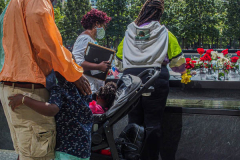 A boy hugs his father as his family place flowers and make a pencil rubbing of the name of their lost family member at the North Pool of the 9/11 memorial. 
Hundreds of people came to the memorial to pay tribute to their family members and loved ones marking the 20th anniversary of the tragedy that struck NYC and shocked the world on 9/11/01. (C) Bianca Otero
