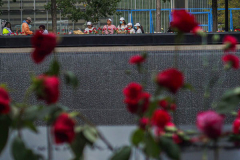 A family place flowers at the name of their lost family member at the North Pool of the 9/11 memorial. 
Hundreds of people came to the memorial to pay tribute to their family members and loved ones marking the 20th anniversary of the tragedy that struck NYC and shocked the world on 9/11/01. (C) Bianca Otero