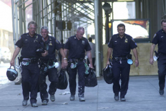 September 13, 2001--World Trade Center--Exhausted looking NYPD police officers from the 102nd Precinct in Queens walk with their helmets and gear to search for survicors in Lower Manhattan/ Ground Zero of the destroyed World Trade Center after terrorists attacked the site with thwo hijacked jetliners two days earlier on Tuesday September 11, 2001. (©2001 Kevin P. Coughlin/Independent Photojournalist)