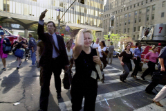 Terrified workers are evacuated from the World Trade Center as debris rains down after two hijacked passenger jets crash into both of the 110-story buildings.