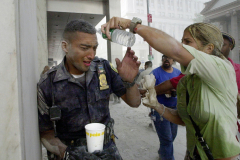 The rescuer becomes the rescued as Police Officer James Valentin cries in pain while a civilian pours water into his eyes to remove burning soot and ash after the World Trade Center towers collapse.