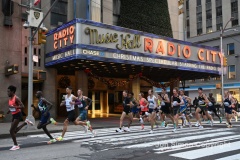 New York City Marathon 21 “Abbott Dash to the Finish” 11/6/21.  A sea of runners take to the streets of Manhattan for the 5K race.  The race is the warmup event one day before the NYC Marathon.  Runners start at the United Nations and run to the Marathon finish line in Central Park. Here the runners run up 6th Avenue past the Radio City Music Hall.  Copyright Jon Simon