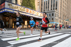 New York City Marathon 21 ÒAbbott Dash to the FinishÓ 11/6/21.  A sea of runners take to the streets of Manhattan for the 5K race.  The race is the warmup event one day before the NYC Marathon.  Runners start at the United Nations and run to the Marathon finish line in Central Park. Here the runners run up 6th Avenue past the Radio City Music Hall.  Copyright Jon Simon