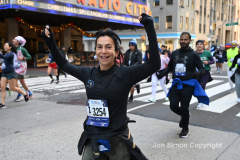 New York City Marathon 21 ÒAbbott Dash to the FinishÓ 11/6/21.  A sea of runners take to the streets of Manhattan for the 5K race.  The race is the warmup event one day before the NYC Marathon.  Runners start at the United Nations and run to the Marathon finish line in Central Park. Here the runners run up 6th Avenue past the Radio City Music Hall.  Copyright Jon Simon