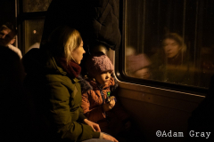 ‘I am a refugee now’, a woman said to me smiling by the side of the track. After covering the Ukrainian exodus into Poland for two weeks I crossed the border with my friend/colleague @tnicholsonphoto , to be able to set eyes on their country from which they are being forced to flee, to try and understand more (if only by a limited amount) about the situation and to ride the same train out that they rode. The train from Lviv was largely full of women and children with the odd man. Everybody made last minute calls. The train stopped for hours in the middle of nowhere. Kids ran around and played on Ukrainian soil, maybe for the last time. Mothers, wives and daughters told me about their previous lives and the men they had left behind. People hugged, cried and kissed. They looked out of train windows at beautiful orthodox churches as a big orange sun set over their land