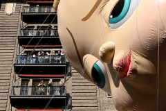 NEW YORK, NEW YORK - NOVEMBER 25: The Boss Baby balloon passes people standing on their balconies in the 95th Macy's Thanksgiving Day Parade on November 25, 2021 in New York City. The Parade has returned to its full size this year after being downsized and closed to the public in 2020 due to the coronavirus pandemic. (Photo by Alexi Rosenfeld/Getty Images)