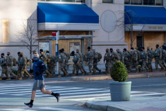 Washington D.C. - JANUARY 19: A person jogs near a team of National Guard soldiers in downtown D.C near the White House and Capitol building on January 19, 2021 in Washington D.C. (Photo by Alexi Rosenfeld)