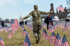 Washington D.C. - JANUARY 21: A soldier from the National Guard picks up American flags and runs with them at the “Field of Flags” on January 21, 2021 in Washington D.C. Due to the Coronavirus pandemic, the National Mall was filled with flags instead of people. (Photo by Alexi Rosenfeld)