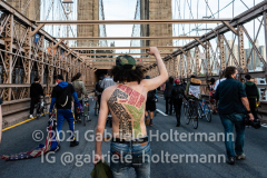 The names of the victims of police brutality are written on the back of a protestor crossing the Brooklyn Bridge in New York City, NY, on the one year anniversary of George Floyd's death on May 25, 2021. (Photo by Gabriele Holtermann for amNY)