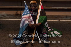 Protesters hold a moment of silence for 9 minutes and 29 seconds on the Brooklyn Bridge  in New York, NY, on the one year anniversary of George Floyd's death on May 25, 2021. (Photo by Gabriele Holtermann for amNY)