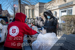 Arlene Di Caterina hands out food donated by Chipotle to Jackson Heights residents in need outside the Salvation Army in Queens, NY,  on Mar. 2, 2021. (Photo by Gabriele Holtermann for Queens Courier)