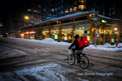 A delivery person braves the cold and snow on his bicycle 2/1/21 in Manhattan.