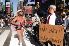 The Naked Cowboy and artist and activist Tootsie Warhol celebrate in Times Square the news that Joe Biden will be the 46th President of The United States.