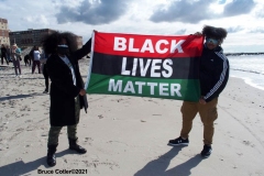 NEW YORK -  Black Surfers Association have a paddle out to honor George Floyd and Daunte Wright in Far Rockaway Queens at Beach 91st. Street. Surfers take to the water hold a prayer circle and place flowers in the water while family members and friends hold signs on the beach.