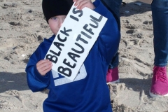 NEW YORK -  Black Surfers Association have a paddle out to honor George Floyd and Daunte Wright in Far Rockaway Queens at Beach 91st. Street. Surfers take to the water hold a prayer circle and place flowers in the water while family members and friends hold signs on the beach.