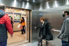 A rider excitedly pushes the button to close the new elevator's doors.
