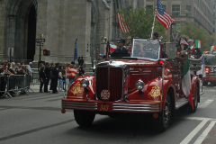 An antique Fire Department vehicle rolls up Fifth Avenue.  The license plate number commemorates the 343 firefighters who died on 9/11.