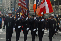 An honor guard from the Fire Department marches along the parade route.