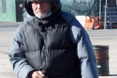 Coney Island Brooklyn. People stroll the Boardwalk in winter clothes on this sunny and cold day, 37 degrees some people sat on benches and others sunned themselves while The Coney Island Polar Bear Club jumped into the Atlantic Ocean for their weekly swim.