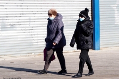 Coney Island Brooklyn. People stroll the Boardwalk in winter clothes on this sunny and cold day, 37 degrees some people sat on benches and others sunned themselves while The Coney Island Polar Bear Club jumped into the Atlantic Ocean for their weekly swim.
