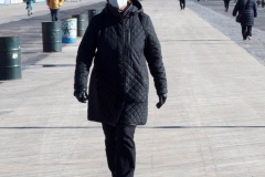 Coney Island Brooklyn. People stroll the Boardwalk in winter clothes on this sunny and cold day, 37 degrees some people sat on benches and others sunned themselves while The Coney Island Polar Bear Club jumped into the Atlantic Ocean for their weekly swim.