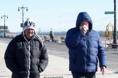 Coney Island Brooklyn. People stroll the Boardwalk in winter clothes on this sunny and cold day, 37 degrees some people sat on benches and others sunned themselves while The Coney Island Polar Bear Club jumped into the Atlantic Ocean for their weekly swim.