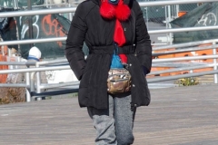 Coney Island Brooklyn. People stroll the Boardwalk in winter clothes on this sunny and cold day, 37 degrees some people sat on benches and others sunned themselves while The Coney Island Polar Bear Club jumped into the Atlantic Ocean for their weekly swim.