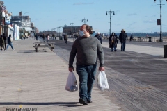 Coney Island Brooklyn. People stroll the Boardwalk in winter clothes on this sunny and cold day, 37 degrees some people sat on benches and others sunned themselves while The Coney Island Polar Bear Club jumped into the Atlantic Ocean for their weekly swim.