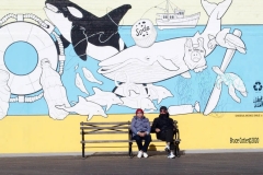 Coney Island Brooklyn. People stroll the Boardwalk in winter clothes on this sunny and cold day, 37 degrees some people sat on benches and others sunned themselves while The Coney Island Polar Bear Club jumped into the Atlantic Ocean for their weekly swim.