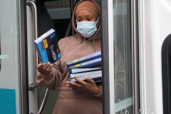 Workers distribute free Binax #COVID19 testing kits on West 125th Street in Harlem, New York City on 24 Dec 2021. The line was over 2 Avenues long