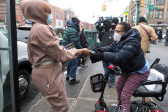 Workers distribute free Binax #COVID19 testing kits on West 125th Street in Harlem, New York City on 24 Dec 2021. The line was over 2 Avenues long