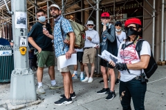 A group of people eating ice-cream look on as the Guardian Angels patrol the Upper West Side in New York City on August 9, 2020.  The neighborhood has experienced an uptick in crime and drugs after hotels have been turned into homeless shelters. (Photo by Gabriele Holtermann)