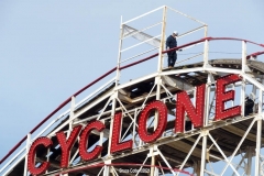 New York- Workers walk the tracks of the World Famous Coney Island Cyclone roller coaster in preparations for opening season. Last summer Coney Island was shut down because of the Covid Pandemic