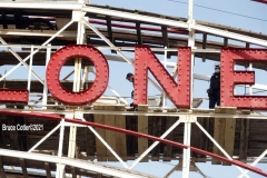New York- Workers walk the tracks of the World Famous Coney Island Cyclone roller coaster in preparations for opening season. Last summer Coney Island was shut down because of the Covid Pandemic