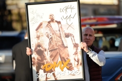 A fan of DMX holds a autographed poster during a funeral procession at Christian Cultural Center in the borough of Brooklyn, New York on Sunday, April 25th, 2021.