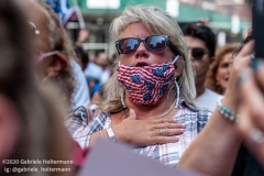 A woman sings the American National Anthem at  the "Don't Give Up the Ship" rally outside City Hall Park in New York City on August 22, 2020. The rally, led by Staten Island based artist Scott LoBaido, called out the Mayor's failure addressing the recent spike in gun violence and increase in homeless encampments. (Photo by Gabriele Holtermann)