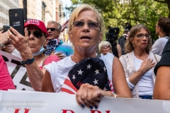 A woman sings the American National Anthem at   the "Don't Give Up the Ship" rally outside City Hall Park in New York City on August 22, 2020. The rally, led by Staten Island based artist Scott LoBaido, called out the Mayor's failure addressing the recent spike in gun violence and increase in homeless encampments. (Photo by Gabriele Holtermann)