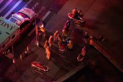 EMTs administer oxygen and check vitals on  two residents of 75 Henry after they had been rescued from their fourth floor balcony.